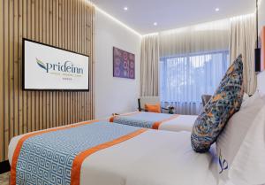 a hotel room with two beds and a window at PrideInn Westlands Luxury Boutique Hotel in Nairobi +19 photos