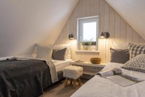 Un dormitorio abuhardillado con dos camas y una ventana. en Wohnung K13, en Borkum