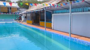 a large swimming pool with flags on the side of a building at Surya Abadi Homestay Syariah RedPartner in Kebumen