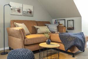 a living room with a brown couch and a table at Pier17 Appartement 3 in Borkum