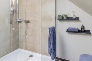 a bathroom with a shower with a glass door at Pier17 Appartement 3 in Borkum +7 photos