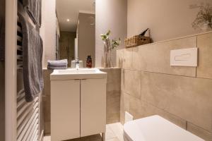 Un baño con un lavabo blanco y un inodoro. en Logierhaus K15 Appartement 1, en Borkum