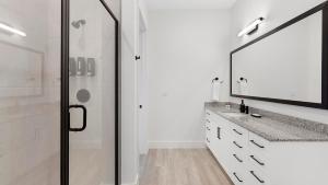 a bathroom with a shower and a sink and a mirror at Landing Apartments - Denton in Denton +66 photos