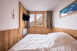 um quarto com uma cama e uma janela em Très Bel Appartement Val Thorens em Val Thorens mais 21 fotografias