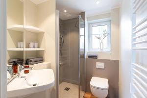 a bathroom with a sink and a toilet and a window at Ferienwohnung Dwarslooper in Borkum