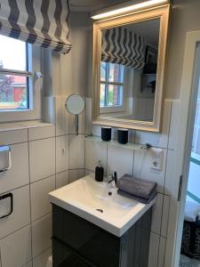 ボルクムにあるFerienhaus Weerts Gatt4の洗面台と鏡のあるバスルーム