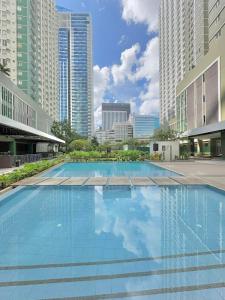 ein großes Schwimmbad in einer Stadt mit hohen Gebäuden in der Unterkunft Avida Riala It Park Fast wifi in Cebu City