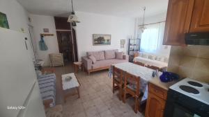 a kitchen and living room with a couch and a table at Captain's George in Livadi