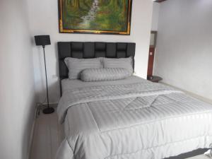a bed in a bedroom with a picture on the wall at Besakih Bonny Homestay in Besakih +32 photos