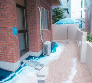 a patio with a heater and an umbrella next to a building at 오션드림스테이 in Busan