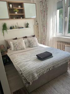 ein Schlafzimmer mit einem großen Bett mit einer Decke darauf in der Unterkunft Mieszkanko w Perle Mazur-Ostroda in Ostróda