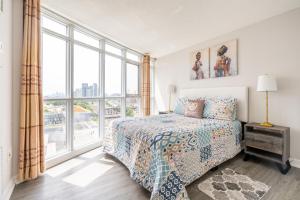 a bedroom with a bed and a large window at Corner 2 Bedroom 2 Bathroom Condo Balcony Iceboat Terrace Downtown Toronto in Toronto
