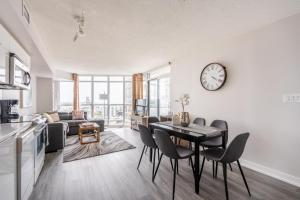 a living room with a table and a clock on the wall at Corner 2 Bedroom 2 Bathroom Condo Balcony Iceboat Terrace Downtown Toronto in Toronto