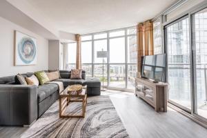 a living room with a couch and a tv at Corner 2 Bedroom 2 Bathroom Condo Balcony Iceboat Terrace Downtown Toronto in Toronto