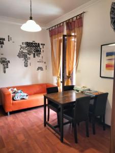 a living room with an orange couch and a table at Casa dell'artista in Molino di Monte Urano