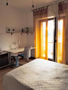 a bedroom with a bed and a desk and a window at Casa dell'artista in Molino di Monte Urano