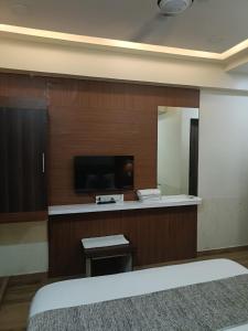 a hotel room with a tv and a mirror at Hotel RJ RESIDENCY in Jāmb
