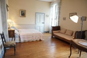 Champagny-sous-UxellesにあるLe Châteauのベッドルーム1室(ベッド1台、ソファ、テーブル付)