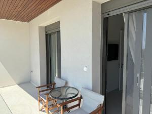 a room with a table and chairs on a balcony at Darion Luxury Villa Nikiti Chalkidiki in Nikiti