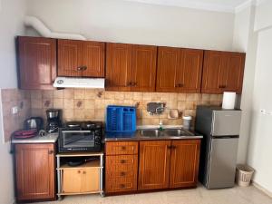 a kitchen with wooden cabinets and a stainless steel refrigerator at Marina's house in Preveza +22 photos