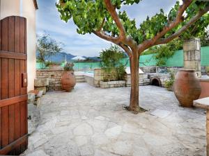 a stone patio with a tree in the middle at Villa in Crete with Vineyard Experience in Kalamítsion Alexándrou