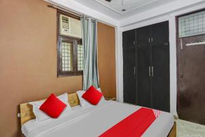 ein Schlafzimmer mit einem Bett mit roten Kissen darauf in der Unterkunft Hotel O Satguru Residency in Ghaziabad