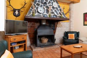 a living room with a fireplace and a tv at Cortijo Villa Ilusion in Arroturas