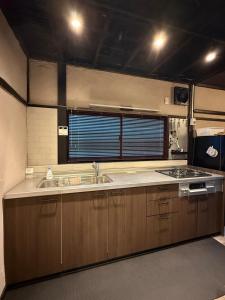 a kitchen with a sink and a stove at 一棟貸し宿 ｍａｉｃｃａ in Numazu