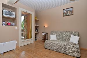 a living room with a couch and a window at Gite Au Milieu Des Chevaux Mérens in Castelnau-Durban
