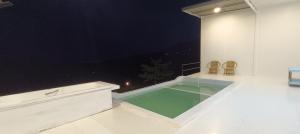 a room with a swimming pool with two chairs at บ้านลิ้นจี่โฮมสเตย์ Baan Lychee homestay in Ban Thung Phan Ha