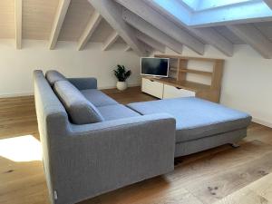 a living room with a couch and a tv at Attico vista Lago in Centro in Luino