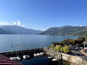 a dock on a lake with boats in the water at Attico vista Lago in Centro in Luino