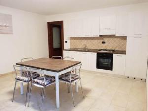 a kitchen with a table and chairs in a room at Residence L'Ancora - Stintino in Stintino +8 photos