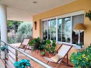 a balcony with two chairs and potted plants at Precioso chalet 4 habitaciones con Piscina comunitaria in Benicàssim