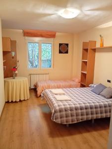 a bedroom with two beds and a table in it at Precioso chalet 4 habitaciones con Piscina comunitaria in Benicàssim