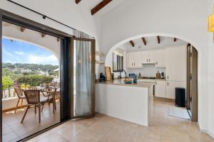 eine Küche und ein Esszimmer mit offenem Torbogen in der Unterkunft Villa Sunset Moraira mit eigenem Pool, Strandnähe, Klimaanlage, Heizung, Outdoor-Küche, Grill in Teulada