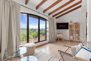 ein Wohnzimmer mit Blick auf einen Balkon in der Unterkunft Villa Sunset Moraira mit eigenem Pool, Strandnähe, Klimaanlage, Heizung, Outdoor-Küche, Grill in Teulada
