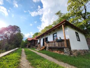 a small white house with a porch at Arboretum Guesthouse in Şoimeni