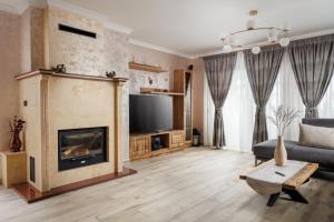 Una sala de estar con chimenea y un sofá. en Vista Valley Resort, en Zărneşti