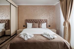 Un dormitorio con una cama grande con toallas blancas. en Vista Valley Resort, en Zărneşti