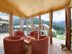 a large room with a table and chairs and windows at Holzchalet nahe Skilift Hohentauern in Hohentauern +23 photos