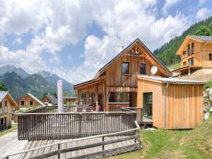a wooden house with a deck and mountains in the background at Holzchalet nahe Skilift Hohentauern in Hohentauern
