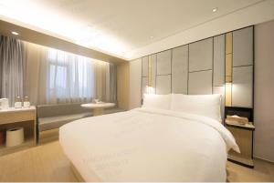 a bedroom with a large white bed and a couch at JI Hotel Beijing Shangdi Anningzhuang in Beijing