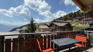 a table and chairs on a balcony with a view of a mountain at Bergquelle Dachwohnung in Bettmeralp