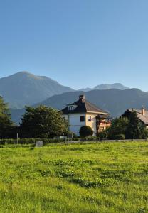 una casa in un campo con montagne sullo sfondo di Vila Moka near Bled-Entire place with Garden Retreat a Lesce