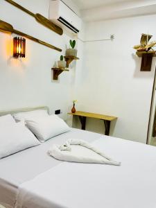 a white bed in a room with a table at Blue Beach Ahangama in Ahangama +11 photos