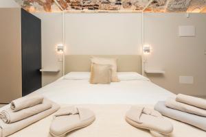 a bedroom with a large white bed with two slippers at Spazio Pardo in Catania