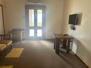 a room with a door and a table and a television at Vyfster - Old Jail in Britstown