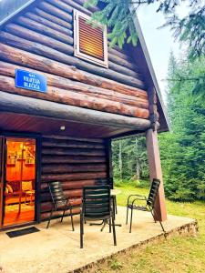 a group of chairs sitting outside of a cabin at Kolibica in Žabljak