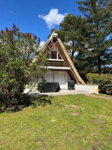 a small house with a thatched roof in a yard at Finnhuette-Seeblick-an-der-Elbe in Lenzen